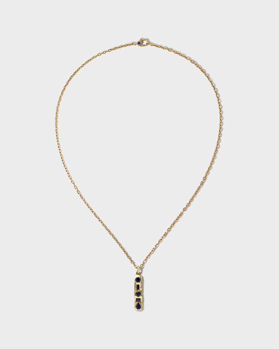 The Ledger Necklace, a 14k yellow gold bar set with five blue sapphires on an oval link chain