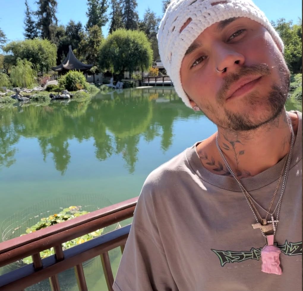 Justin Bieber by a pond wearing the pink Jesus Peace